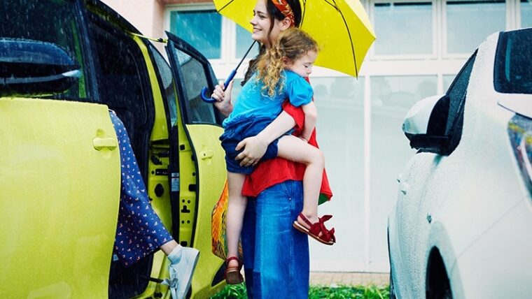 シエンタに乗り込む傘を持った女性と抱っこされた女の子